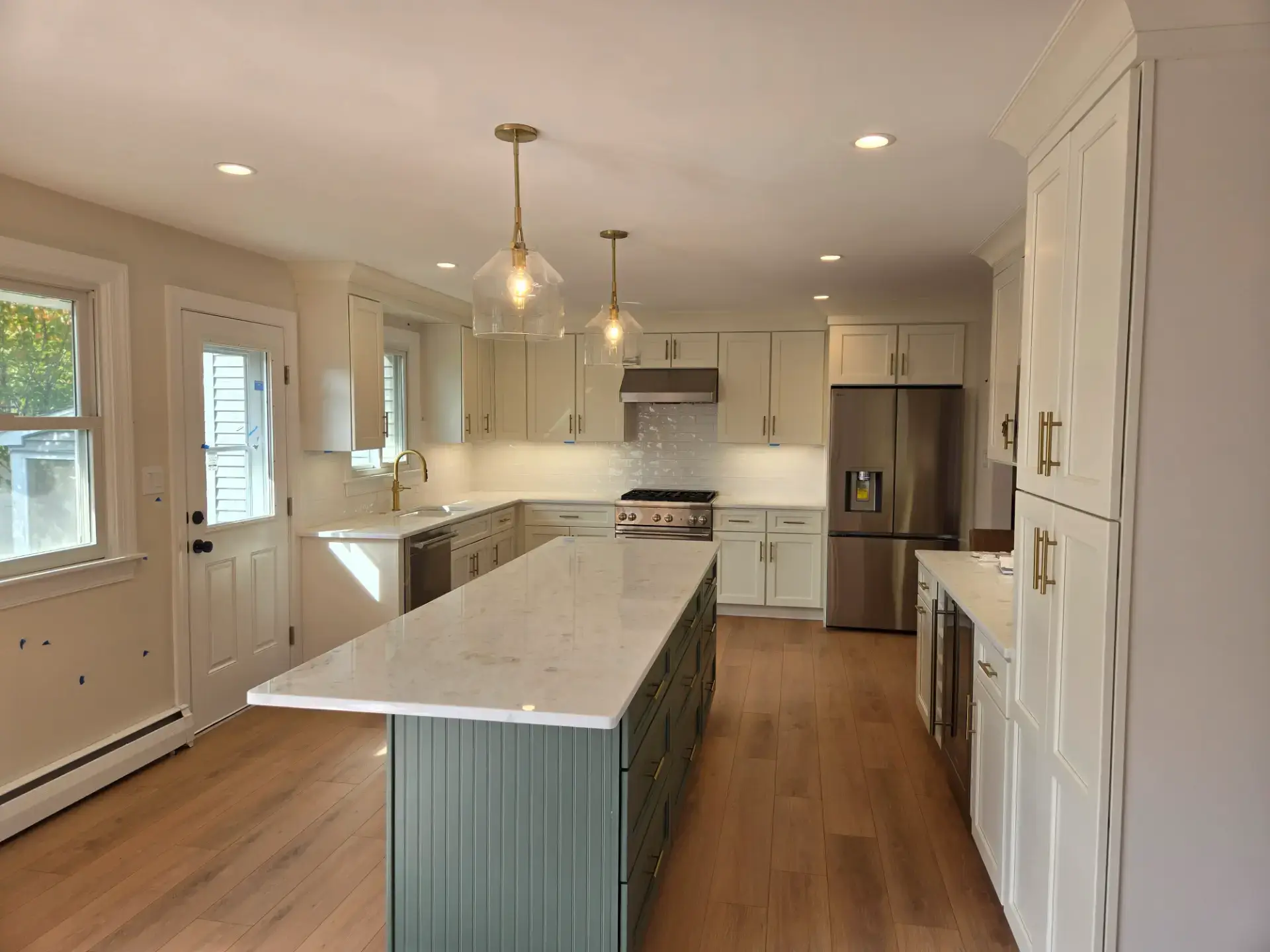 Kitchen with a green island and white perimeter cabinetry